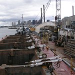 Dump scows SE103 and SE104 shown during an extensive re-fit in Boston, MA during the summer of 2005.

The SE103 and SE104 are six pocket bottom dump scows. Their dimensions are 170ft. long by 43ft wide with a moulded depth of 16 ft. 